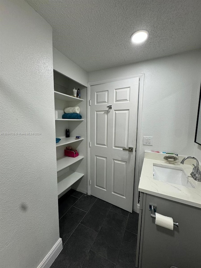 bathroom with vanity, tile patterned floors, and a textured ceiling