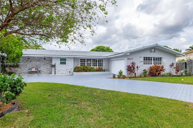 single story home with a garage and a front lawn