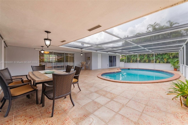 view of swimming pool with a patio area and glass enclosure