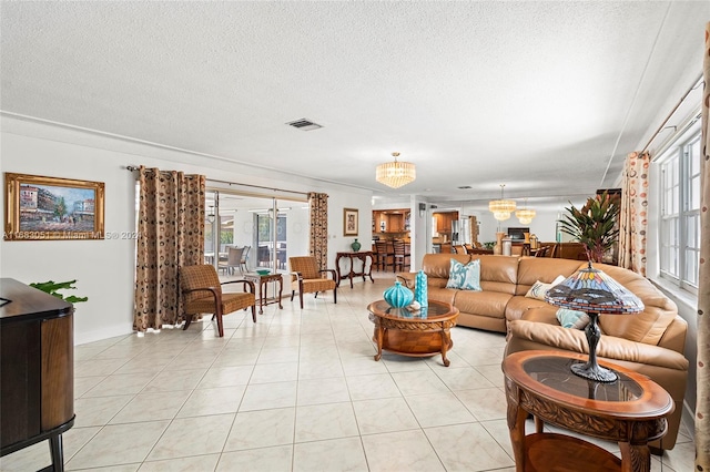 living room featuring a notable chandelier, a textured ceiling, and light tile patterned flooring