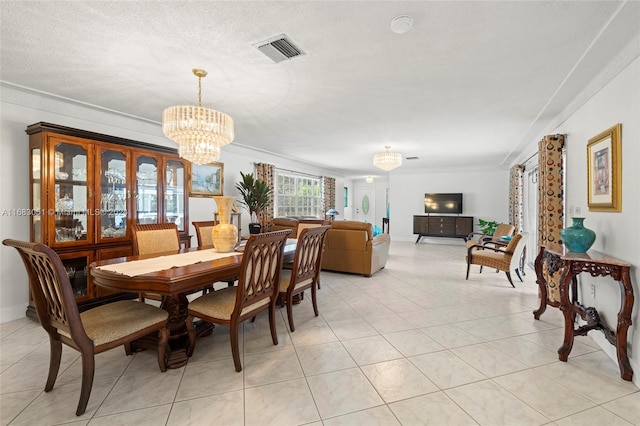 tiled dining room featuring ornamental molding, a chandelier, and a textured ceiling