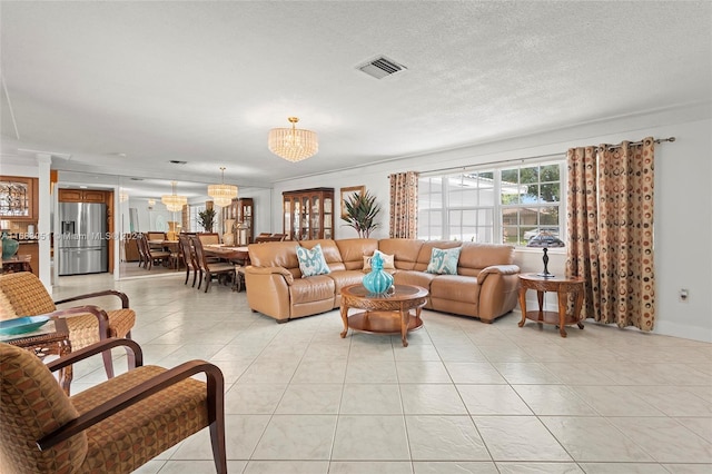 tiled living room with crown molding, a textured ceiling, and an inviting chandelier