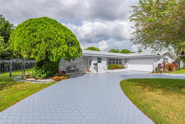 view of front of home with a front yard and a garage