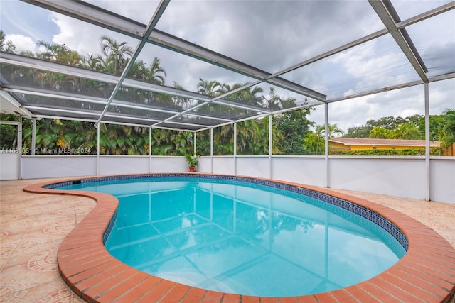 view of swimming pool featuring a patio area and glass enclosure