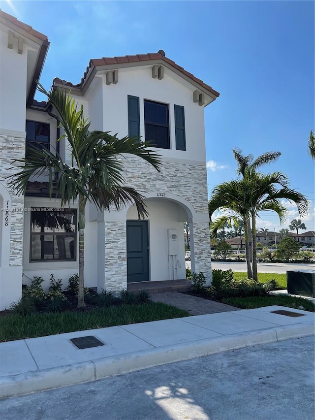 mediterranean / spanish house with stucco siding and stone siding