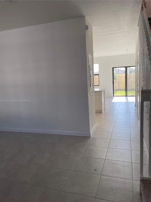 unfurnished room featuring light tile patterned floors and baseboards