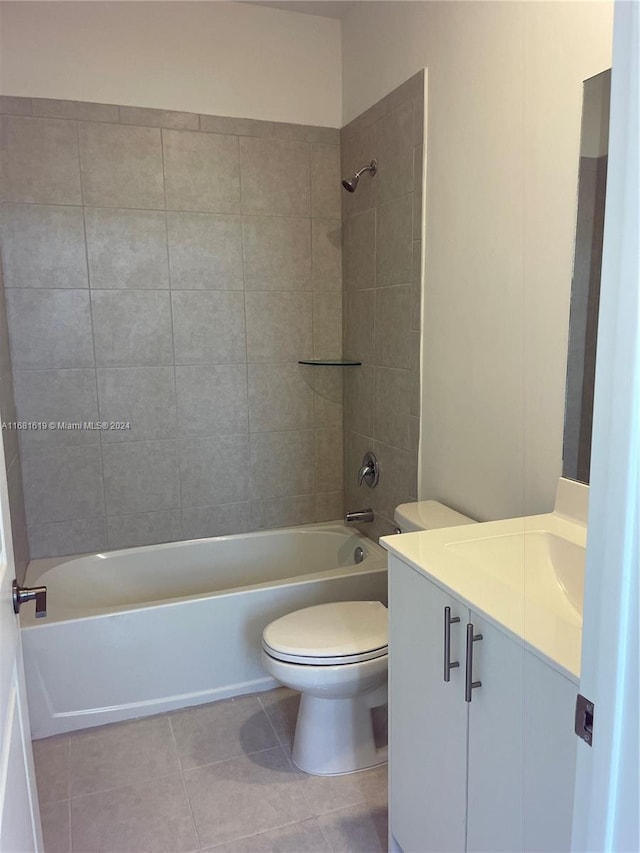 full bathroom featuring tiled shower / bath, vanity, toilet, and tile patterned floors