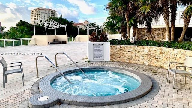 view of swimming pool with a hot tub and a patio area