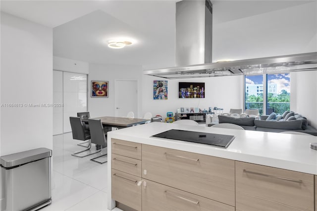 kitchen with light brown cabinetry, light tile patterned floors, and black electric cooktop