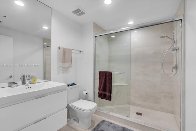 bathroom featuring vanity, toilet, tile patterned flooring, and an enclosed shower