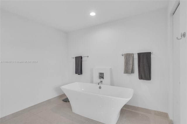 bathroom with a tub to relax in and tile patterned floors