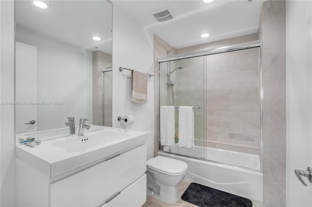 full bathroom featuring vanity, toilet, tile patterned floors, and enclosed tub / shower combo