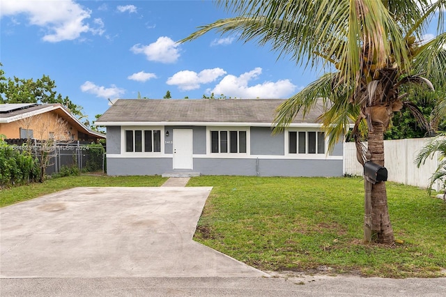 view of front facade with fence, stucco siding, and a front lawn
