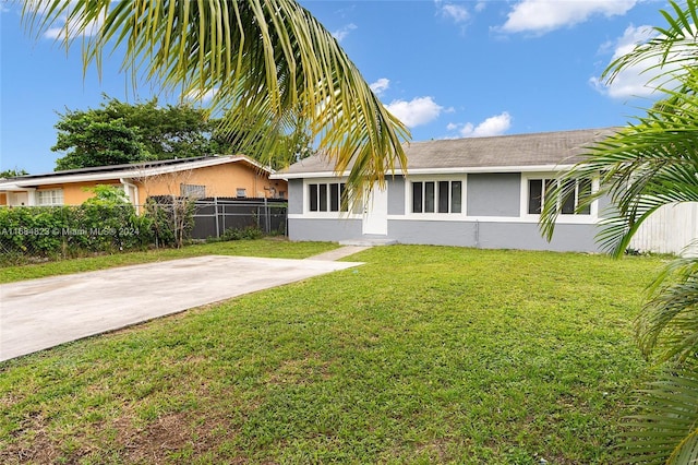 rear view of property featuring stucco siding, a yard, and fence