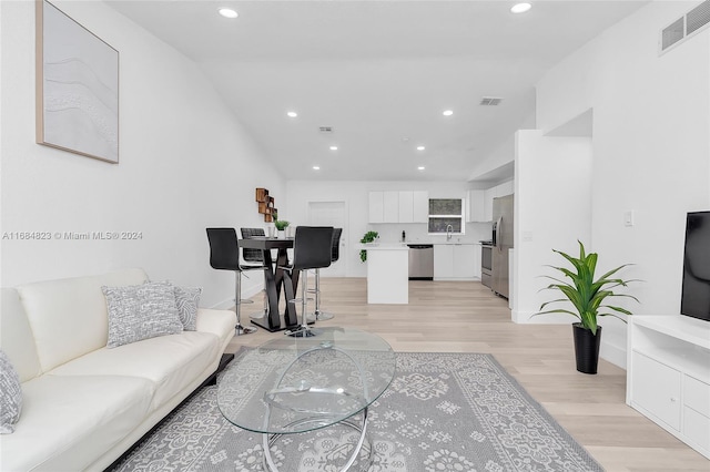 living room with light hardwood / wood-style floors and sink