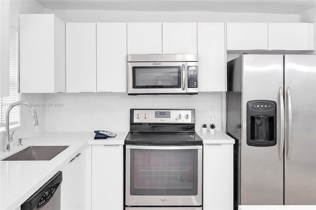 kitchen featuring sink, appliances with stainless steel finishes, and white cabinetry