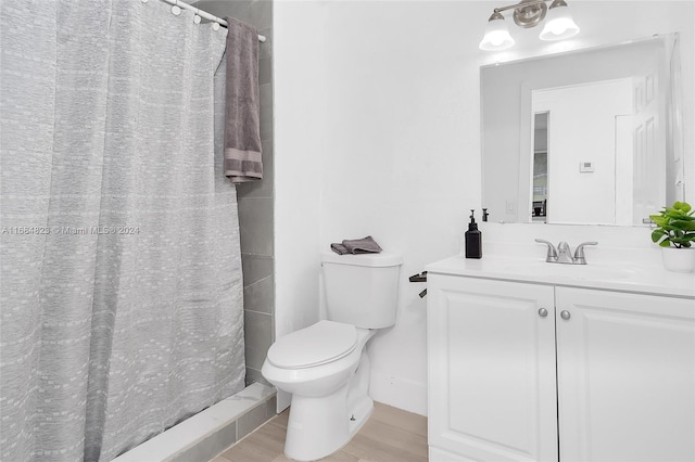 bathroom with vanity, toilet, hardwood / wood-style flooring, and walk in shower