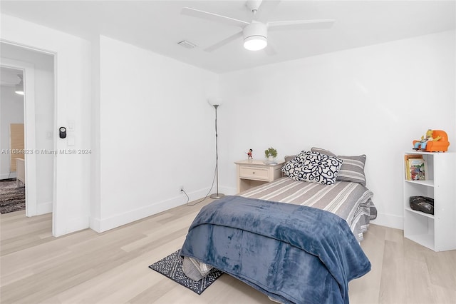 bedroom with visible vents, light wood-style flooring, ceiling fan, and baseboards