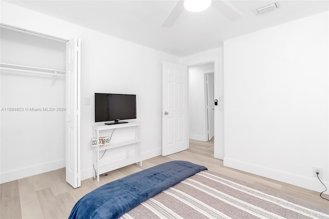 bedroom with ceiling fan, baseboards, wood finished floors, visible vents, and a closet