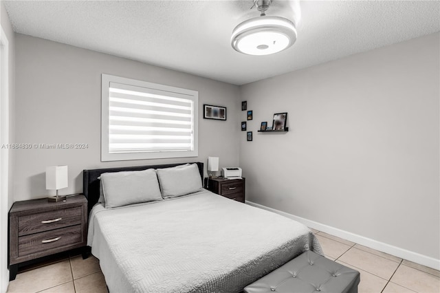 bedroom with a textured ceiling and light tile patterned flooring