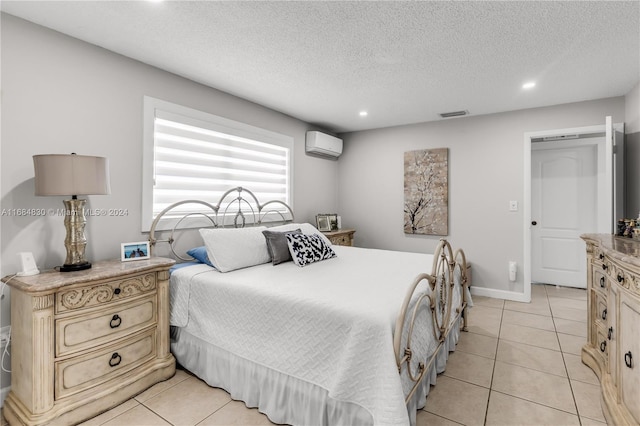 tiled bedroom with an AC wall unit and a textured ceiling