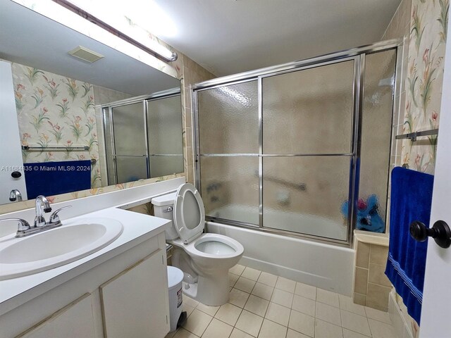 laundry room with stacked washer / dryer, light tile patterned flooring, a textured ceiling, and electric panel