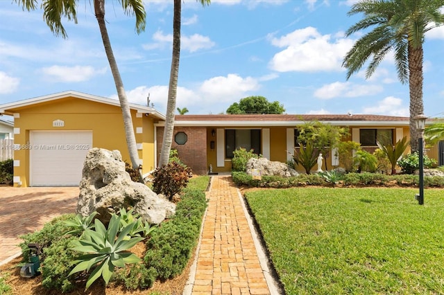 single story home featuring a garage and a front lawn