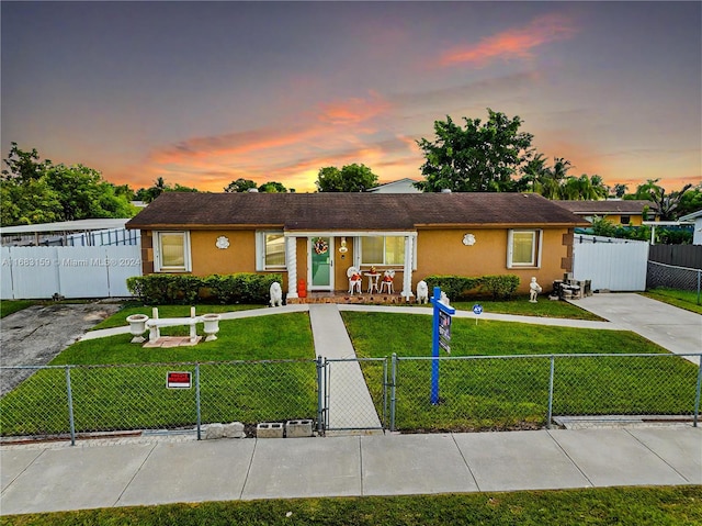 ranch-style home with a yard