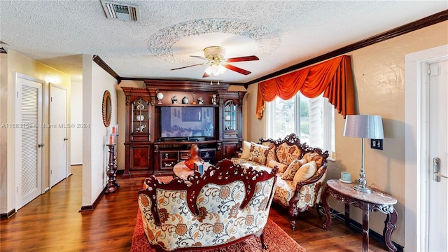 living room featuring ceiling fan, ornamental molding, and a textured ceiling