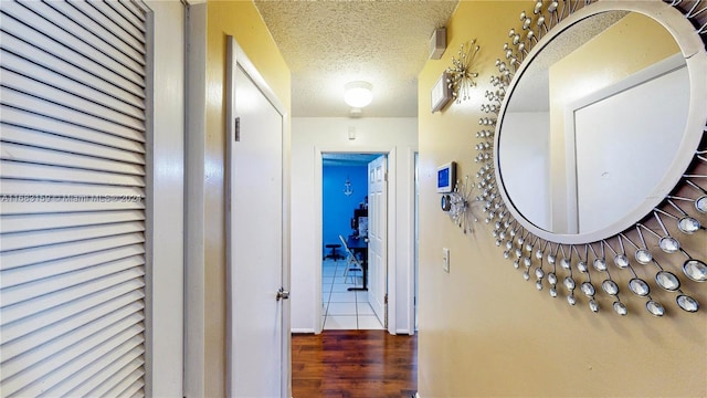 hall featuring a textured ceiling and hardwood / wood-style floors