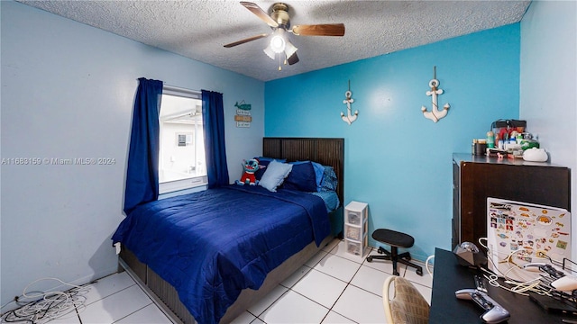 bedroom featuring ceiling fan, light tile patterned floors, and a textured ceiling