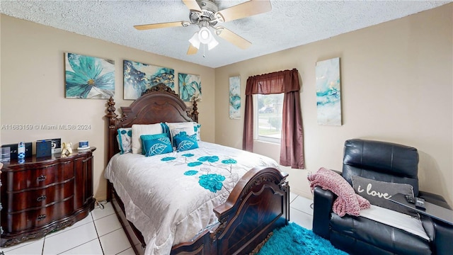 tiled bedroom with ceiling fan and a textured ceiling