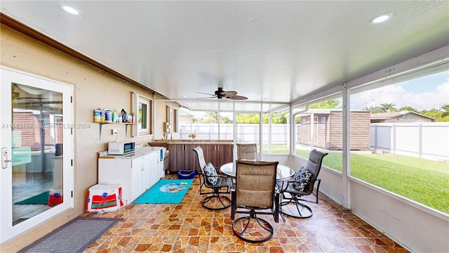 sunroom / solarium featuring ceiling fan