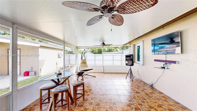 sunroom / solarium featuring ceiling fan and plenty of natural light