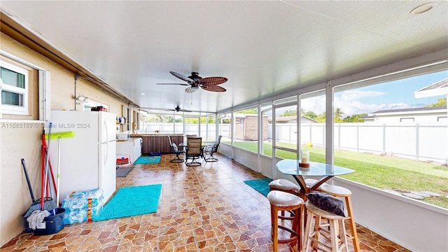 sunroom with ceiling fan and plenty of natural light