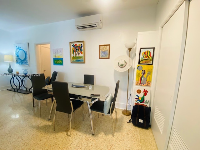 dining room with a wall mounted air conditioner, baseboards, and speckled floor