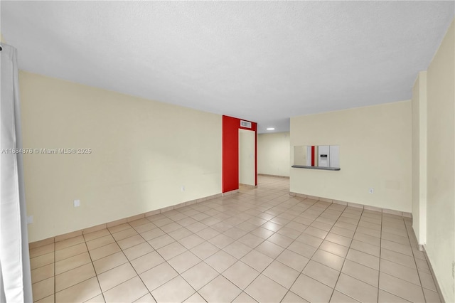 unfurnished room featuring light tile patterned floors and a textured ceiling