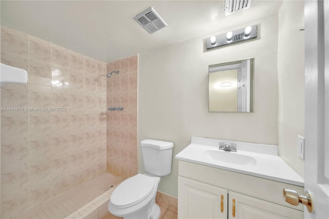 bathroom featuring tiled shower, tile patterned floors, toilet, and vanity