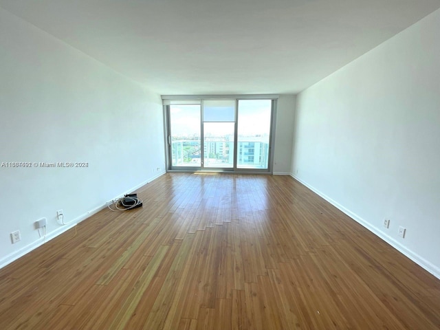 empty room with baseboards and wood finished floors