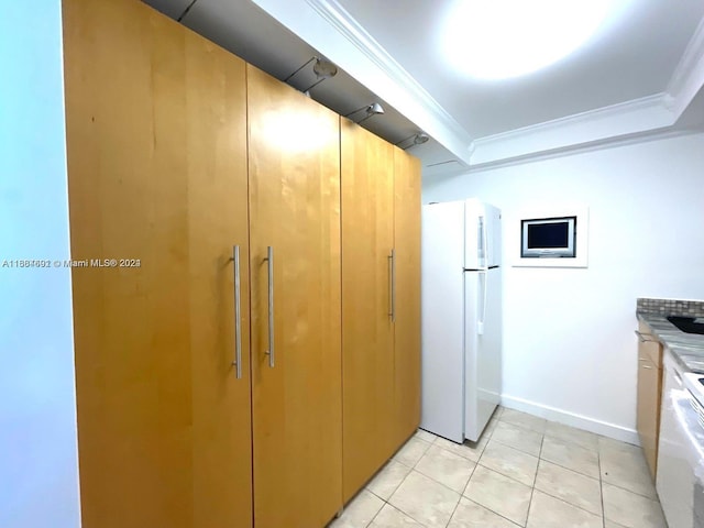 kitchen featuring ornamental molding, light tile patterned floors, and white refrigerator