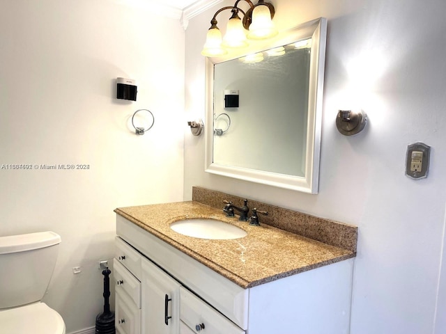 bathroom with toilet, crown molding, and vanity