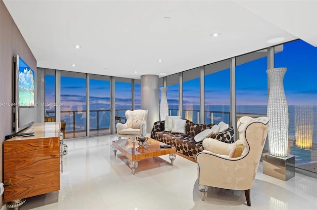 living room with a water view, floor to ceiling windows, and light tile patterned floors