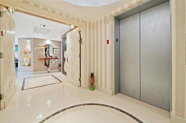 hall featuring elevator and light tile patterned floors