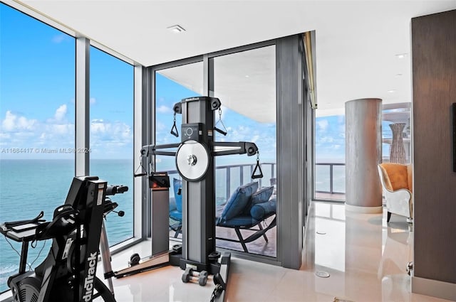 workout room with expansive windows, plenty of natural light, and a water view