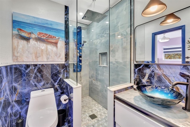 bathroom with decorative backsplash, toilet, vanity, tile walls, and a tile shower