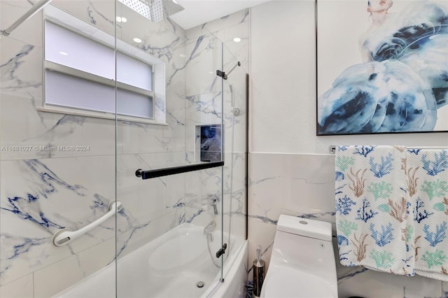 bathroom featuring toilet, tile walls, and tiled shower / bath