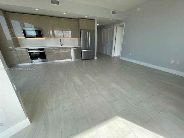 kitchen with appliances with stainless steel finishes, sink, and gray cabinets