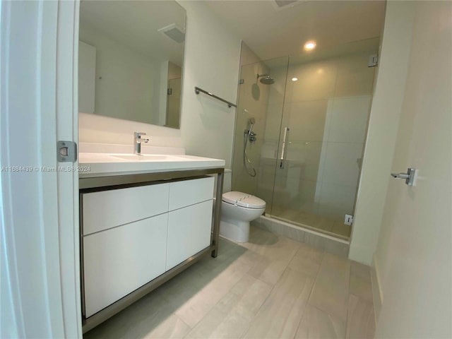 bathroom featuring vanity, toilet, and walk in shower