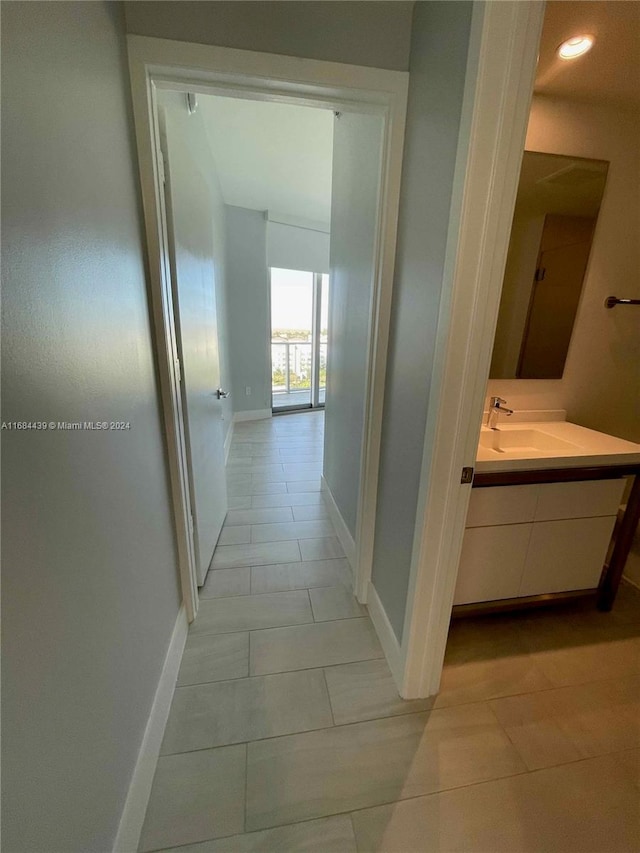 corridor with light tile patterned floors and sink