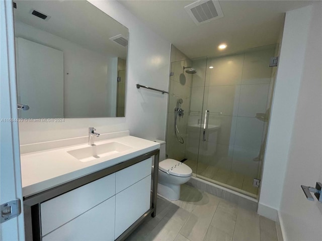 bathroom featuring vanity, toilet, tile patterned flooring, and a shower with door